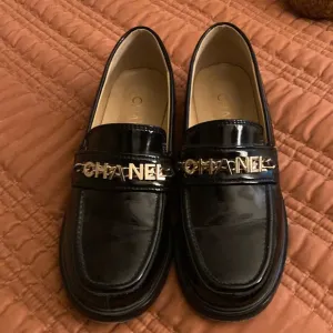 Shiny black faux leather loafers.